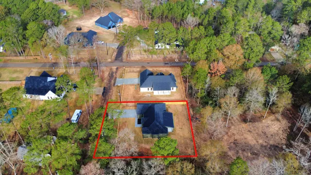 an aerial view of a house with a yard and large trees