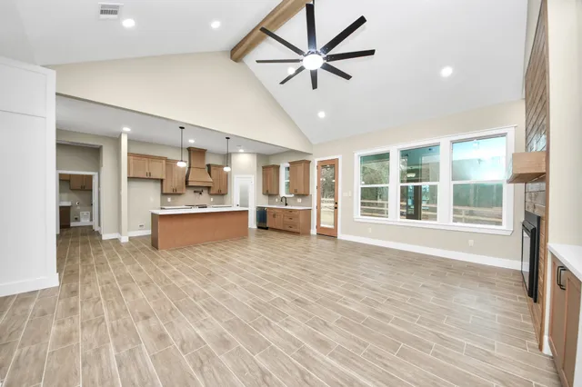 a view of a kitchen with refrigerator and wooden floor