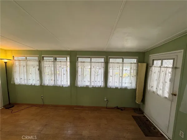a view of a hallway with wooden floor and closet