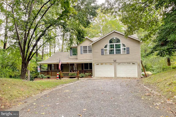 a front view of a house with a yard and trees