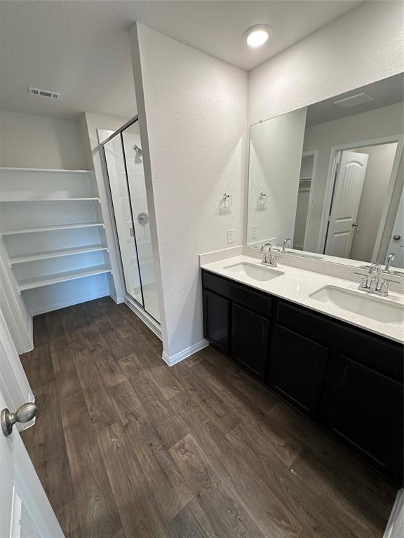 563 Evergreen Sumac Loop Kyle, TX 78640 - Photo 14 of 18 A well-appointed primary bathroom showcases dual vanities and a modern shower enclosure.