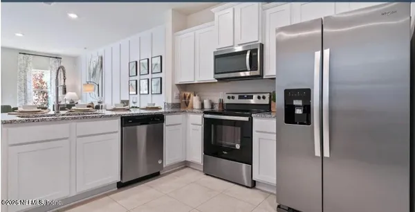 a kitchen with stainless steel appliances granite countertop a refrigerator a stove top oven a sink and dishwasher