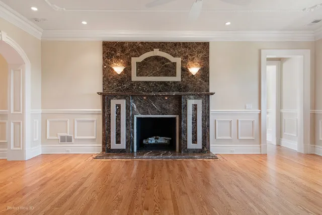 an empty room with wooden floor a fireplace and entryway