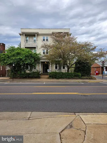 a view of a building and car parked on the road