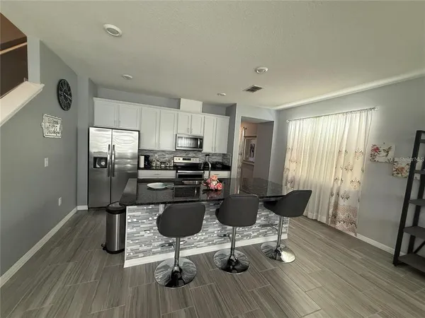 a living room with furniture a wooden floor and next to a window