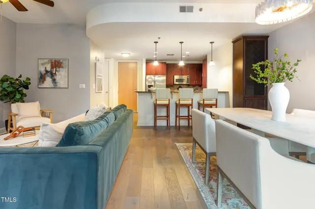 a living room with furniture kitchen and a potted plant