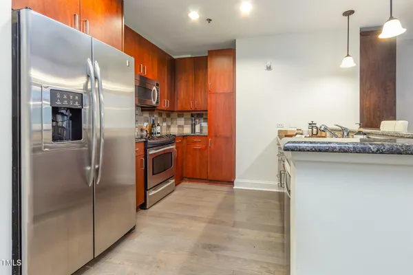 a kitchen with stainless steel appliances granite countertop a refrigerator and a sink
