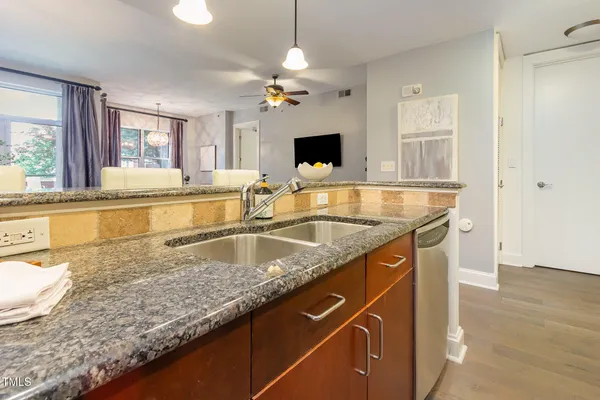 a kitchen with granite countertop a sink a counter top space and cabinets