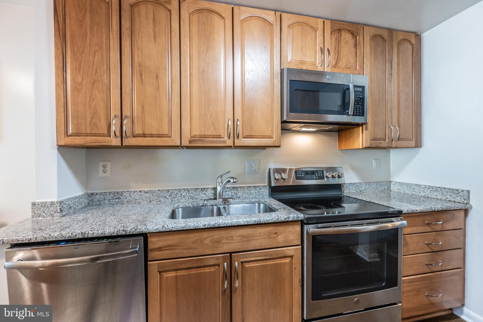 11917 Barrel Cooper Court Reston, VA 20191 - Photo 4 of 59 a kitchen with granite countertop a stove and a microwave
