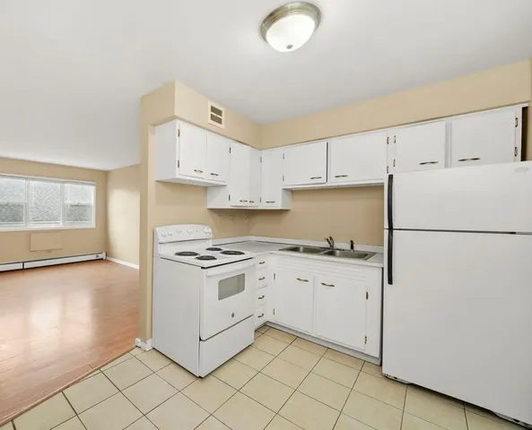 a kitchen with white cabinets and white appliances
