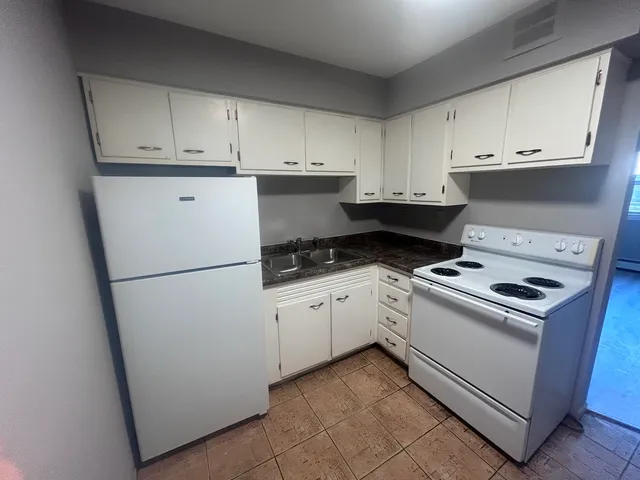 a kitchen with white cabinets and white appliances
