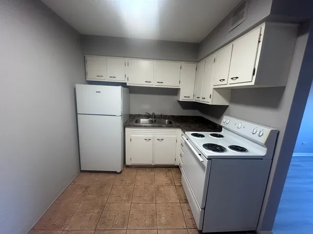 a kitchen with a stove top oven and cabinets