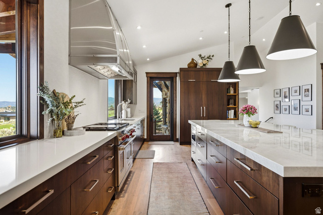 7885 North Rabbitbrush Court, Unit 13 Park City, UT 84098 - Photo 13 of 88 Modern kitchen featuring rich wood cabinetry, light countertops, and a full suite of stainless steel appliances including a professional-grade range with a stainless steel vent hood