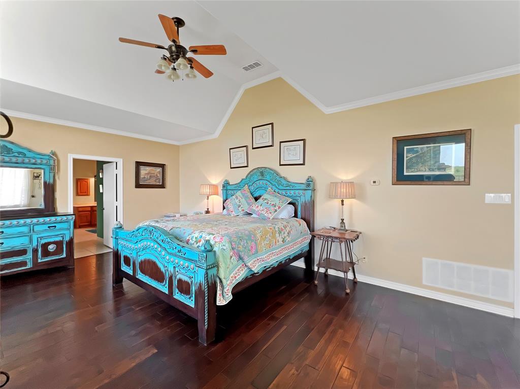 590 County Road 385 Valley View, TX 76272 - Photo 18 of 38 a bedroom with a bed a dresser and potted plants