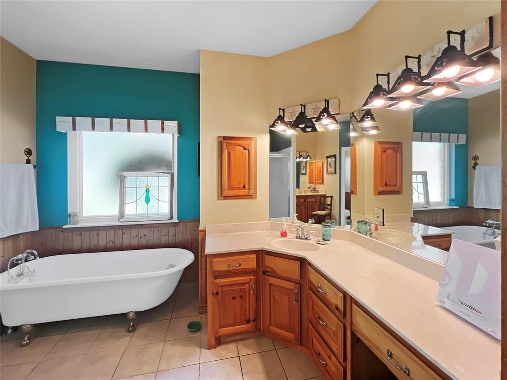 590 County Road 385 Valley View, TX 76272 - Photo 20 of 38 a spacious bathroom with a bathtub sink and mirror