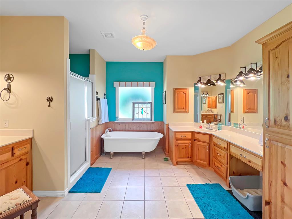 590 County Road 385 Valley View, TX 76272 - Photo 21 of 38 a spacious bathroom with a tub sink and mirror