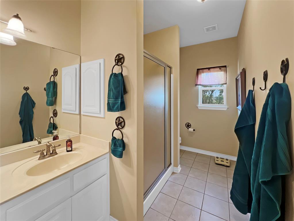 590 County Road 385 Valley View, TX 76272 - Photo 24 of 38 a bathroom with a sink a mirror and a shower