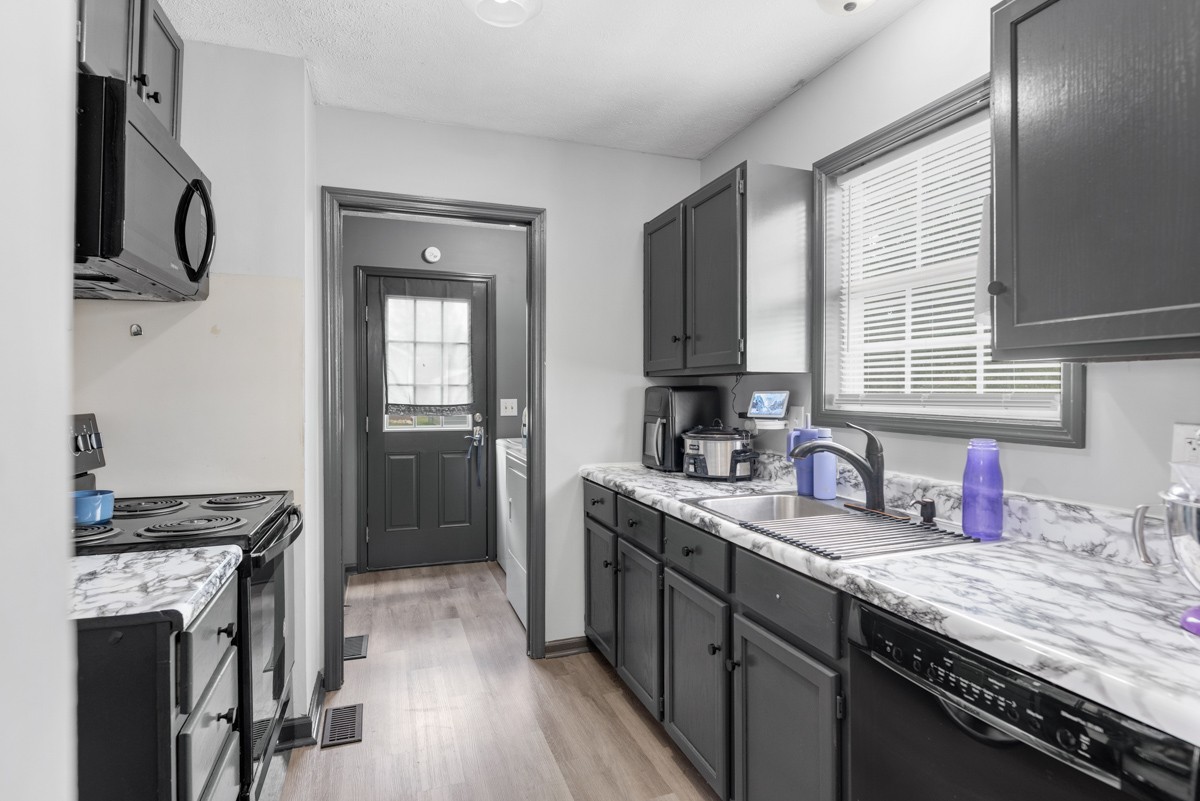 560 Gregory Road Westmoreland, TN 37186 - Photo 21 of 41 a kitchen with stainless steel appliances granite countertop a sink stove and refrigerator