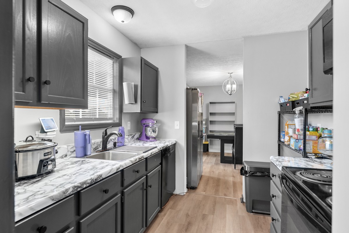 560 Gregory Road Westmoreland, TN 37186 - Photo 22 of 41 a kitchen with stainless steel appliances granite countertop a sink stove and refrigerator