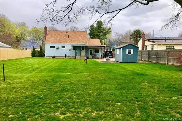 a view of a house with a yard and sitting area