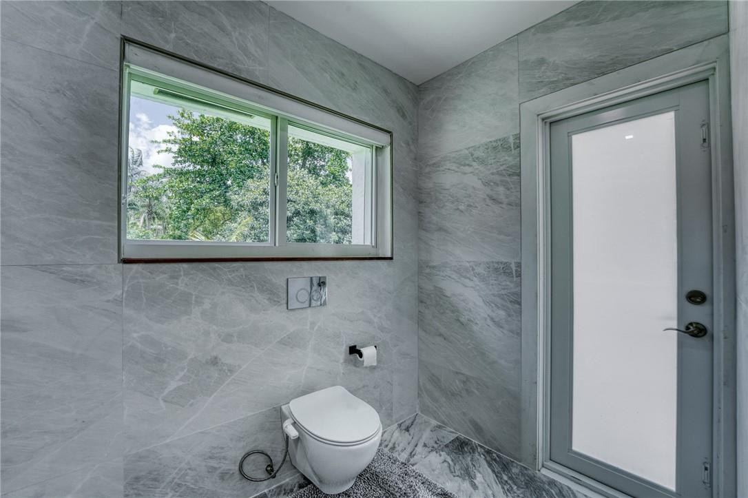 5901 Cypress Road Plantation, FL 33317 - Photo 26 of 99 a bathroom with a granite countertop toilet a sink and a window