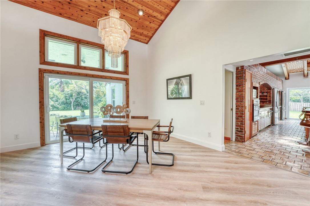 5901 Cypress Road Plantation, FL 33317 - Photo 36 of 99 a dining room with wooden floor a chandelier a glass table and chairs