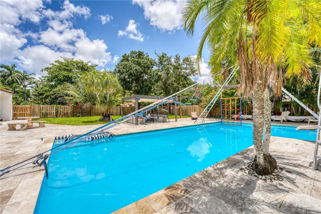 5901 Cypress Road Plantation, FL 33317 - Photo 76 of 99 a view of a swimming pool with a yard and sitting area