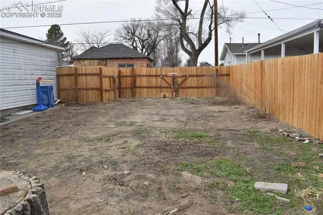 a view of a house with a yard and large tree