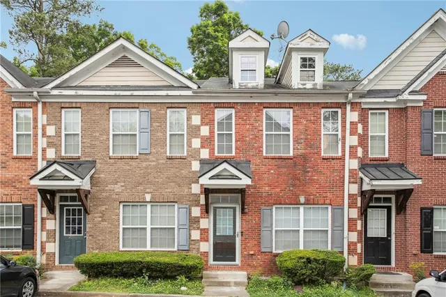 a front view of a residential houses with yard and parking space