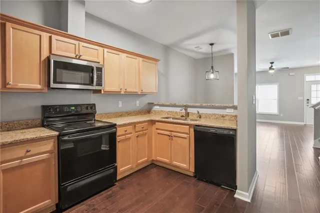 a kitchen with stainless steel appliances granite countertop a stove a sink and a microwave