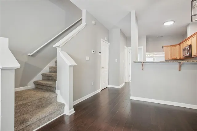 a view of a hallway with wooden floor and staircase