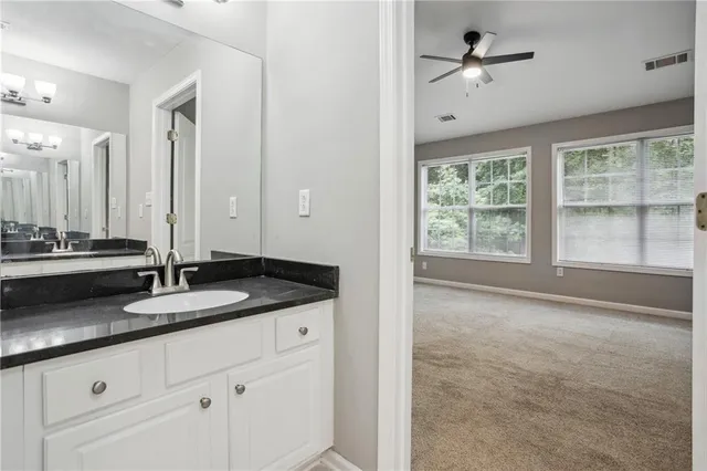 a bathroom with a granite countertop sink and a mirror