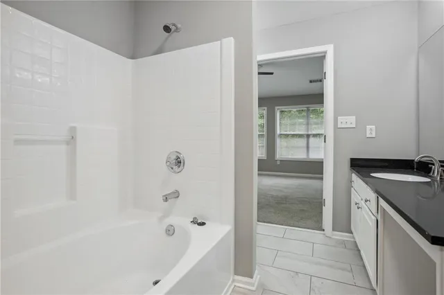 a bathroom with a granite countertop sink a toilet and shower