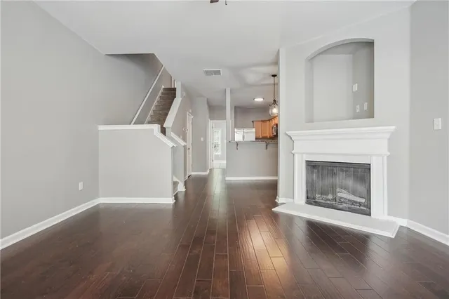 a view of a livingroom with wooden floor and a fireplace