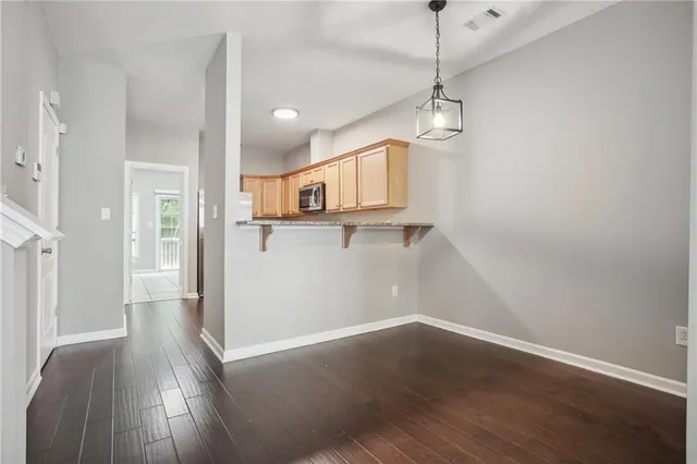 a view of a kitchen with wooden floor and a ceiling fan