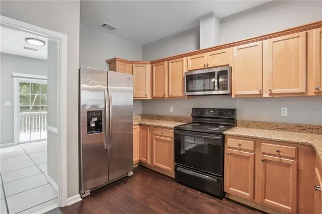 a kitchen with stainless steel appliances granite countertop a refrigerator stove and sink