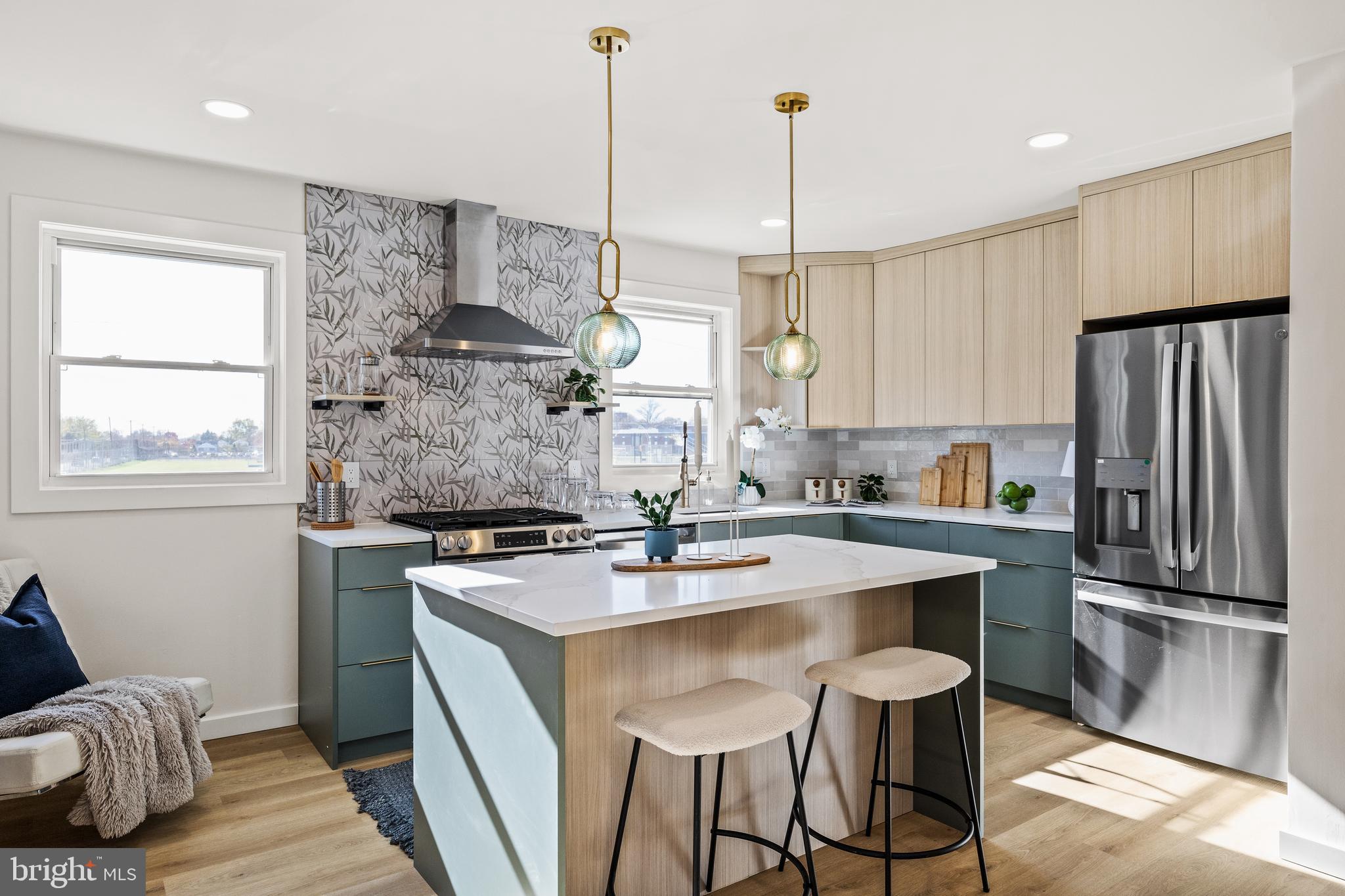 a kitchen with kitchen island a stove a sink a refrigerator and chairs