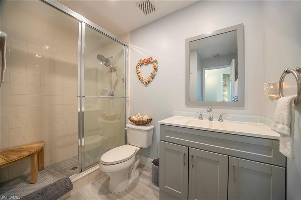 1160 Reserve Way, Unit 303 Naples, FL 34105 - Photo 11 of 19 a bathroom with a toilet sink vanity and mirror