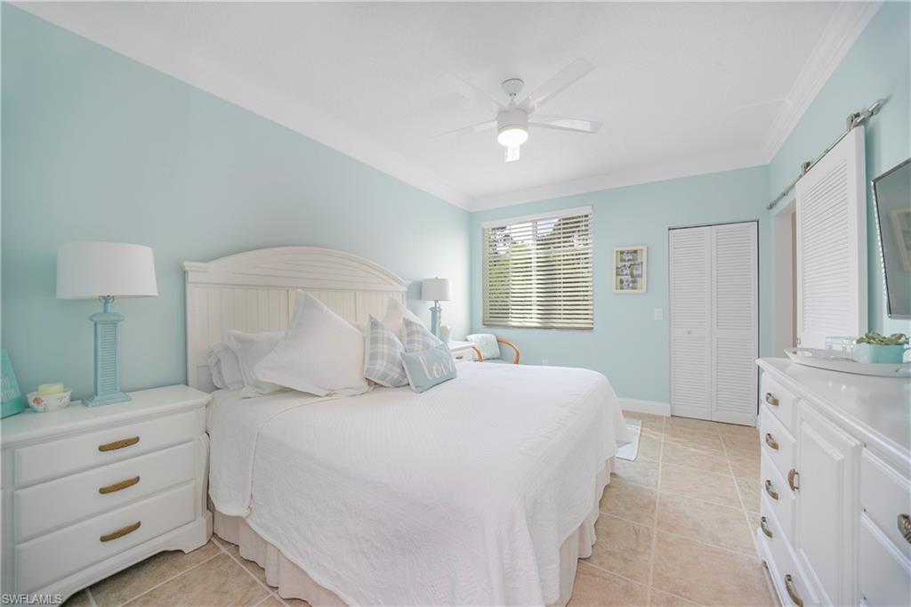 1160 Reserve Way, Unit 303 Naples, FL 34105 - Photo 5 of 19 a bedroom with a bed and a chandelier