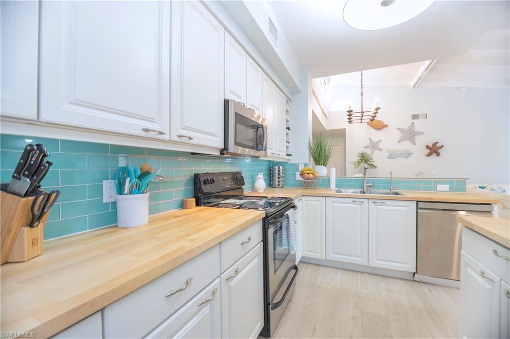 1160 Reserve Way, Unit 303 Naples, FL 34105 - Photo 7 of 19 a kitchen with stainless steel appliances granite countertop a sink a stove and cabinets