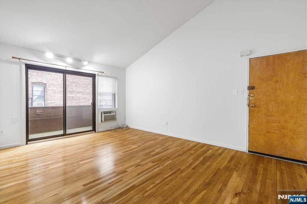 70 Orient Way, Unit 9 Rutherford, NJ 07070 - Photo 3 of 16 a view of an empty room with wooden floor and a window