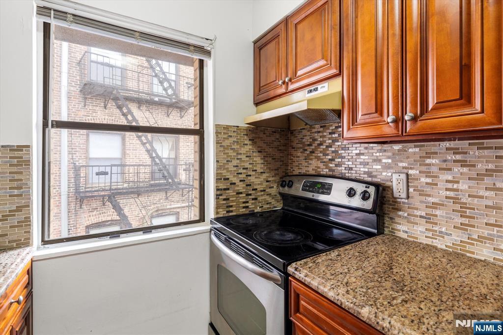 70 Orient Way, Unit 9 Rutherford, NJ 07070 - Photo 6 of 16 a kitchen with granite countertop a stove sink and cabinets