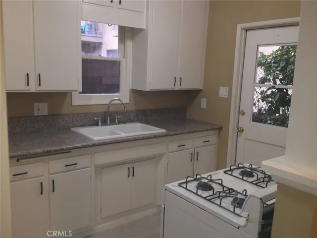 a kitchen with a sink stove and cabinets