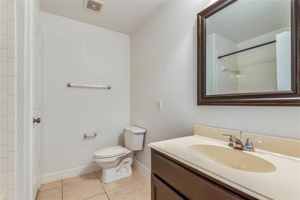 1513 Rosson Road Little Elm, TX 75068 - Photo 15 of 17 a bathroom with a granite countertop sink toilet and mirror