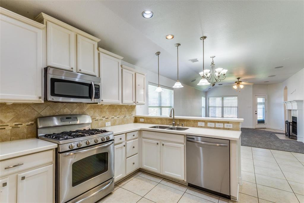 1513 Rosson Road Little Elm, TX 75068 - Photo 3 of 17 a kitchen with a stove a sink and a microwave