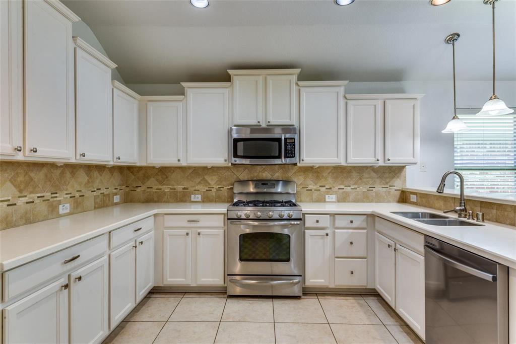1513 Rosson Road Little Elm, TX 75068 - Photo 4 of 17 a kitchen with cabinets stainless steel appliances and a sink