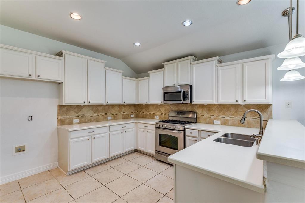 1513 Rosson Road Little Elm, TX 75068 - Photo 5 of 17 a kitchen with white cabinets stainless steel appliances and sink