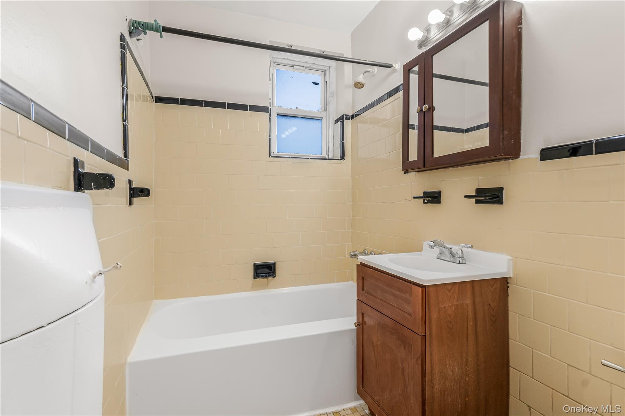 84-50 169th Street, Unit 418 Queens, NY 11432 - Photo 14 of 15 Bathroom with vanity, tile walls, and tub / shower combination