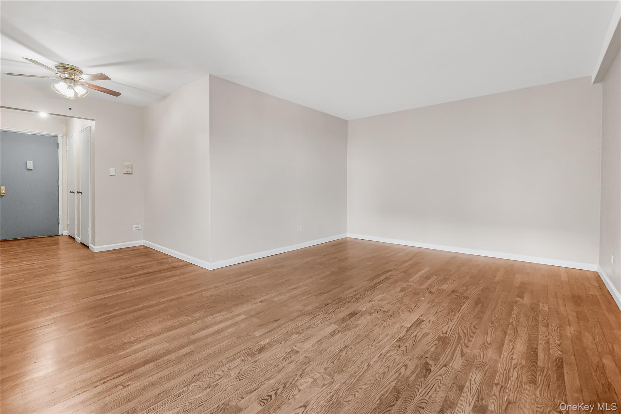 84-50 169th Street, Unit 418 Queens, NY 11432 - Photo 5 of 15 Empty room with light wood-type flooring and ceiling fan