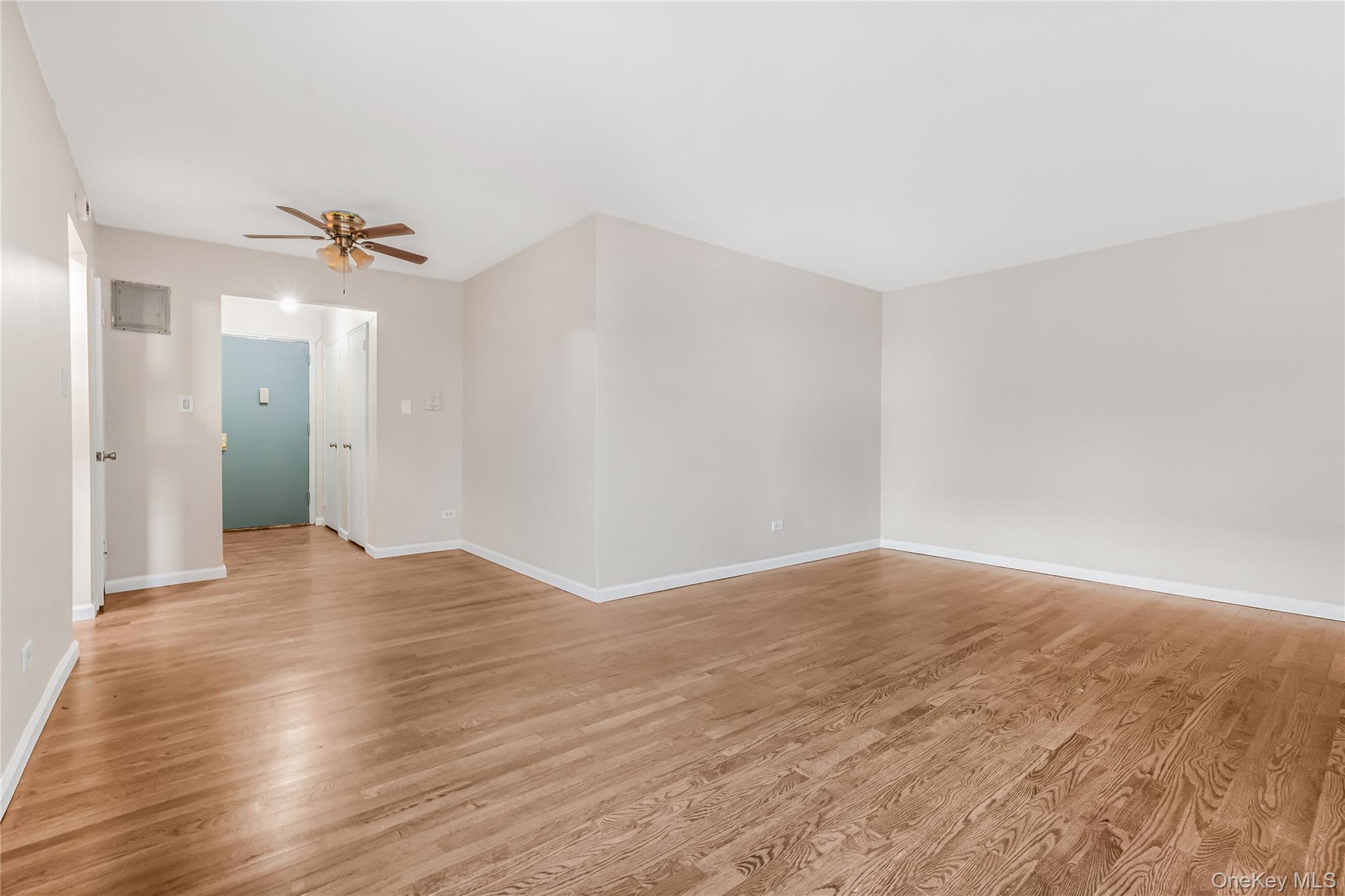 84-50 169th Street, Unit 418 Queens, NY 11432 - Photo 8 of 15 Unfurnished room with light wood finished floors and a ceiling fan